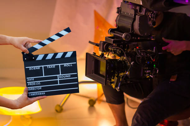 A person holding a clapper board in front of a camera.