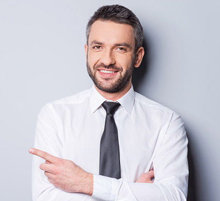 A man in a white shirt and tie smiling warmly.
