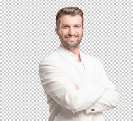 A confident man in a white suit stands with arms crossed, wearing a warm smile on his face.