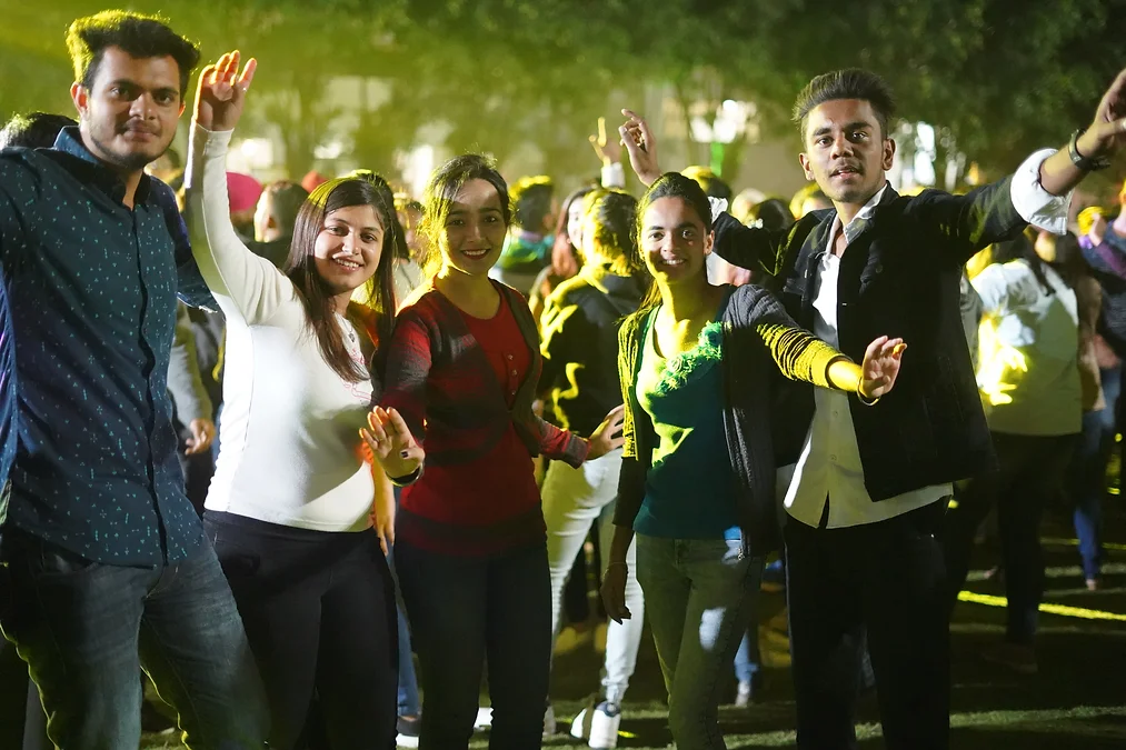 A lively party scene with a group of people joyfully dancing together, creating a vibrant and energetic atmosphere.